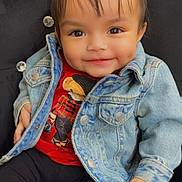 Zayanna joined the competition — help win amazing prizes! baby, black_pants, button, buttoned_jacket, child, clothing, cushioned_chair, cute, denim_jacket, face, hair, happy, indoor, person, pigtails, portrait, red_shirt, sitting, smile, young_child
