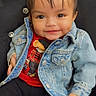 baby, black_pants, button, buttoned_jacket, child, clothing, cushioned_chair, cute, denim_jacket, face, hair, happy, indoor, person, pigtails, portrait, red_shirt, sitting, smile, young_child