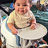 baby, child, high_chair, smiling, indoor, tshirt, sneakers, table, furniture, person, cute, happy, infant, face, clothing, seated, home, toy, blanket, wooden_table