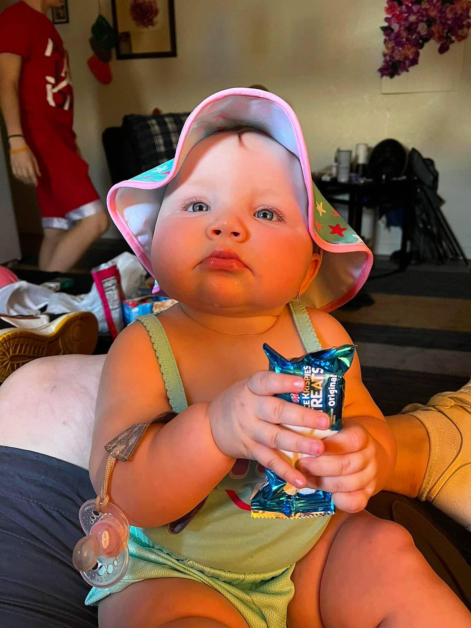 Dahlia is registered to the contest to win money with this photo: baby, baby_toddler_clothing, cap, chair, cheek, child, event, fashion_accessory, fun, happy, headwear, human_leg, jewellery, nail, person, room, sitting, skin, thigh, thumb