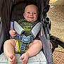 baby, smiling, stroller, outdoor, child, happy, blue_eyes, seatbelt, green_clothing, barefoot, infant, cute, person, sunlight, legs, feet, diaper, fabric, sitting, closeup