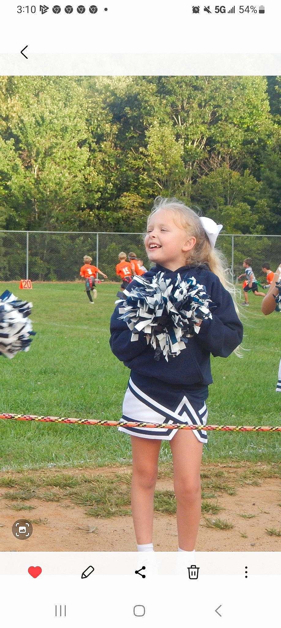 Marilyn is registered to the contest to win money with this photo: ball_game, championship, cheerleading_uniform, competition_event, fence, fun, games, grass, joy, person, plant, player, recreation, shorts, smile, sports, sports_uniform, t_shirt, team, team_sport