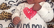 Nyaire is registered to the contest to win money with this photo: baby, infant, smiling, onesie, clothing, pattern, leopard_print, heart, blanket, happy, cute, sleepwear, child, face, fist, young, lying_down, adorable, joyful, indoor