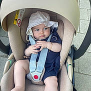 Celia a rejoint le concours — aidez-le/la à gagner de superbes lots ! baby, infant, car_seat, stroller, hat, white_hat, navy_blue_clothing, safety_straps, pavement, outdoor, child, cute, plush, seat, foot, hand, face, expression, sunhat, baby_bracelet