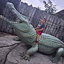 Théo participe au concours pour gagner de l'argent avec cette photo : child, boy, statue, alligator, outdoor, playground, marvel_tshirt, red_shorts, sneakers, fence, rocks, posing, daylight, green, sculpture, nature, plants, concrete, fun, casual