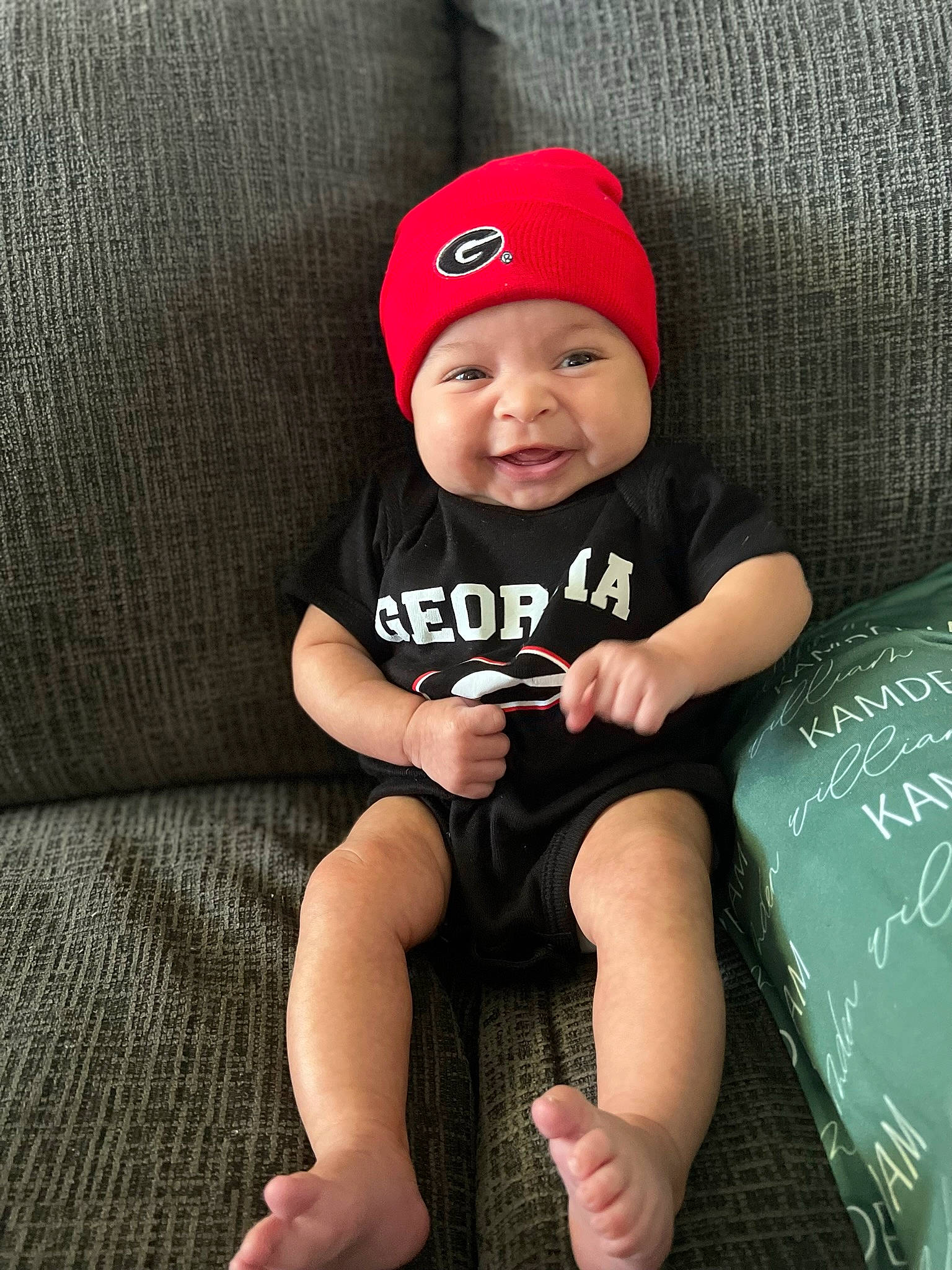 Kamden joined the competition — help win amazing prizes! baby, baby_toddler_clothing, baseball_cap, cap, child, comfort, costume_hat, couch, flash_photography, fun, headwear, human_leg, knee, lap, pattern, person, sitting, skin, sleeve, smile
