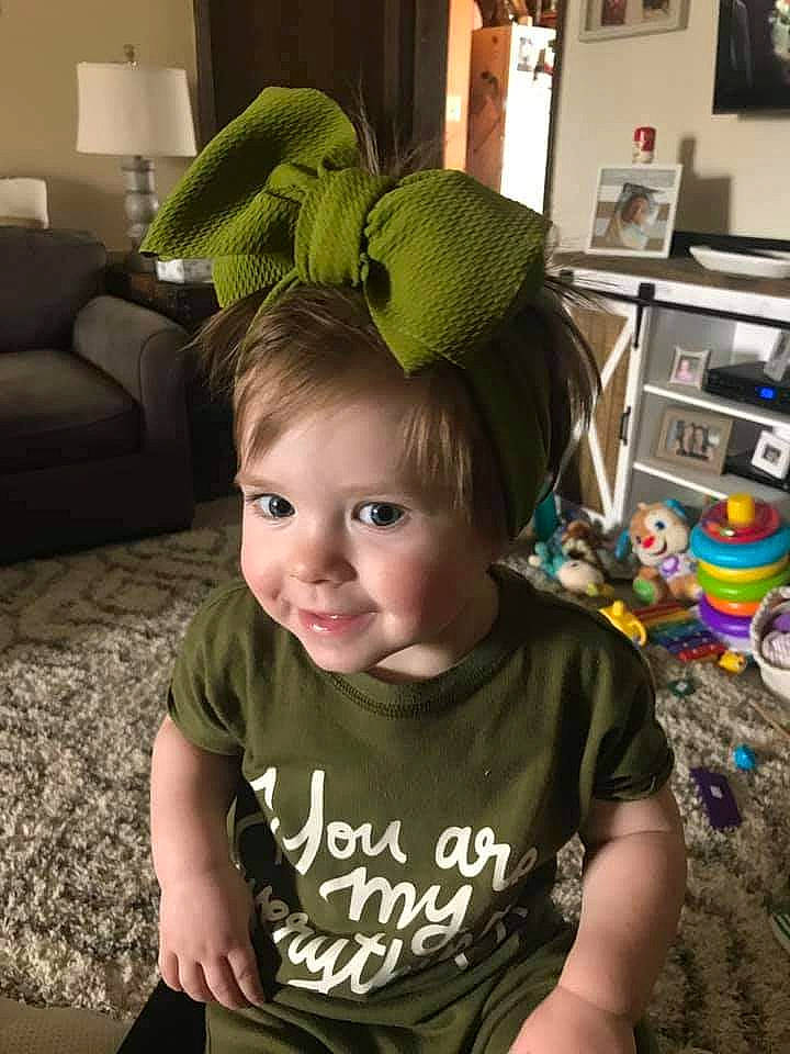 Joelle is registered to the contest to win money with this photo: baby, baby_toddler_clothing, blurred, cap, child, comfort, cool, couch, eye, face, floor, flooring, fun, happy, head, kitchen_appliance, person, sitting, sleeve, smile