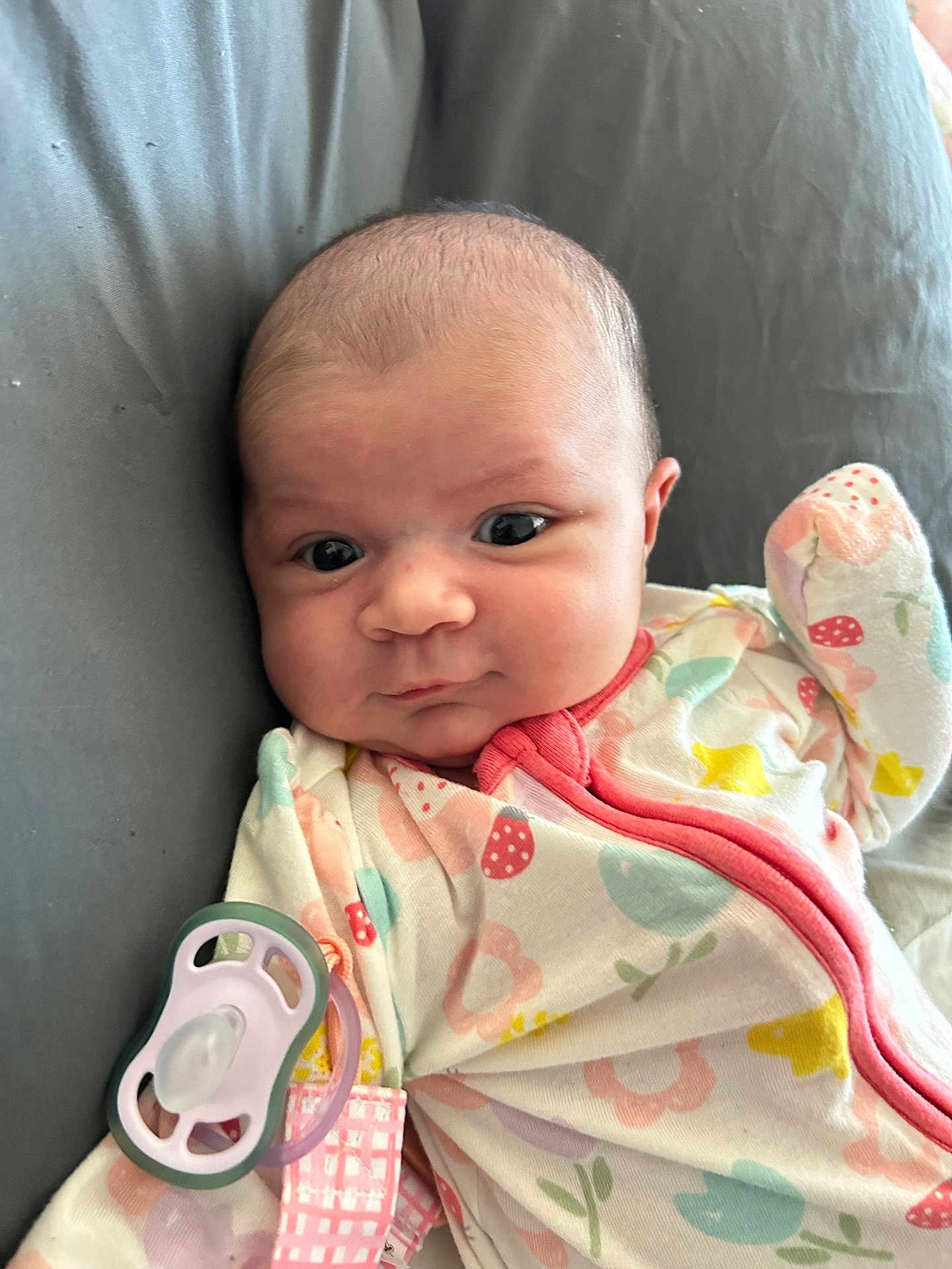 Ireland joined the competition — help win amazing prizes! baby, infant, face, pacifier, onesie, clothing, cute, child, expression, lying_down, pink, patterned_clothing, soft_toys, comfort, indoor, young_child, cushion, closeup, skin, newborn