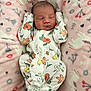 baby, newborn, sleeping, onesie, floral_pattern, blanket, pink, soft_texture, infant, cute, peaceful, cozy, hands_up, face, head, closed_eyes, child, portrait, indoors, resting