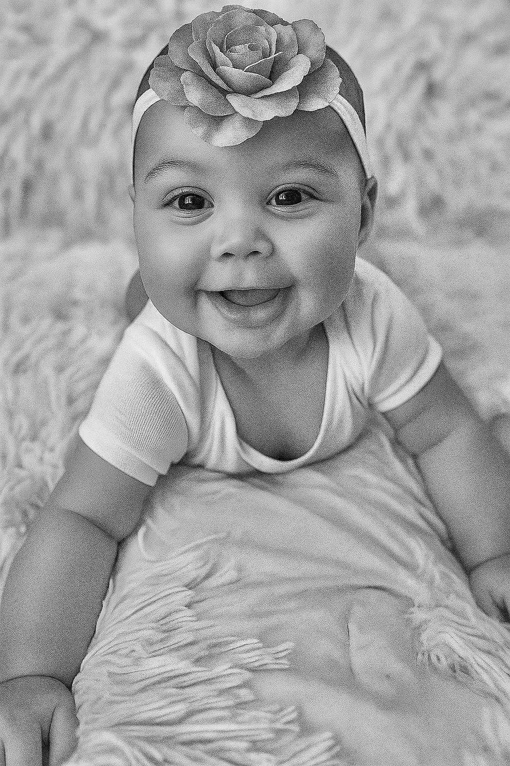 Honey joined the competition — help win amazing prizes! baby, infant, smiling, face, headband, flower, blanket, texture, black_and_white, portrait, cute, happy, child, skin, eyes, mouth, clothing, hand, lying_down, baby_girl