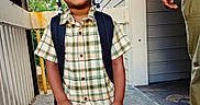 Nicholas joined the competition — help win amazing prizes! child, glasses, braids, plaid_shirt, backpack, standing, outdoor, porch, smiling, hands_in_pockets, casual_clothing, person, young, happy, fashion, feet, adult, doorway, concrete_floor, sunlight