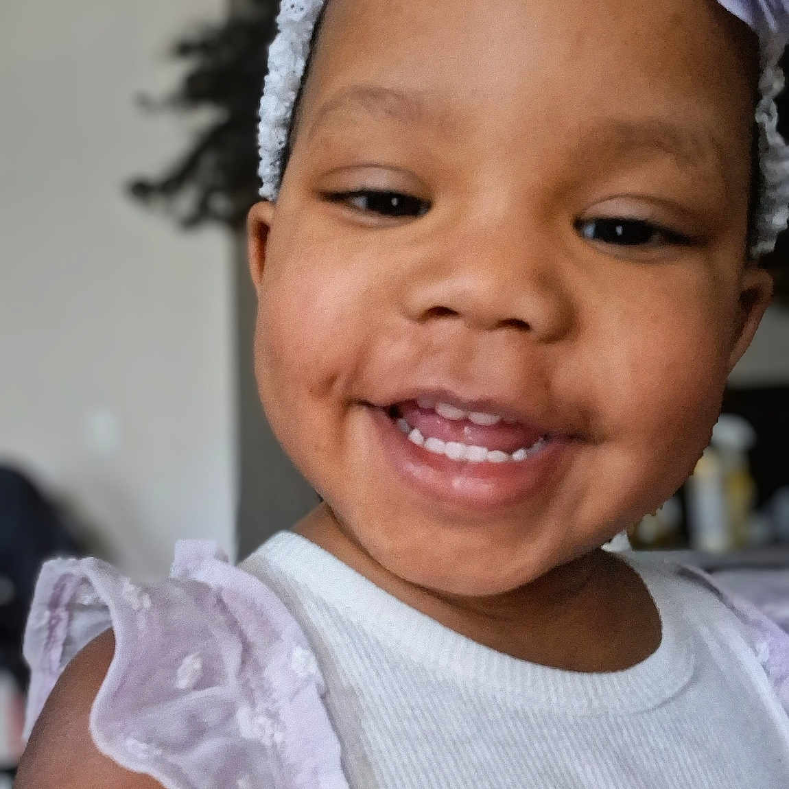 Nylah is registered to the contest to win money with this photo: toddler, smile, child, headband, purple, white_top, ruffles, happy, face, portrait, indoor, young_child, cute, person, fashion, clothing, closeup, expression, hair, fun