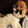 Jeff is registered to the contest to win money with this photo: person, cat, glasses, indoor, leather_chair, black_and_white_cat, sleeping_cat, close_up, relaxed, snuggling, portrait, adult, casual_clothing, home, comfort, resting, face, feline, pet, warm