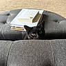 cat, black_cat, pet, animal, feline, green_eyes, face, ears, whiskers, indoors, living_room, couch, sofa, furniture, books, book_stack, fabric, gray, peeking, portrait