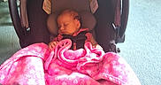 Aerial joined the competition — help win amazing prizes! baby, car_seat, blanket, pink, sleeping, infant, child, indoors, floor, carrying_handle, clothing, head_support, person, toddler, floral_pattern, fabric, comfort, rest, seat, quiet