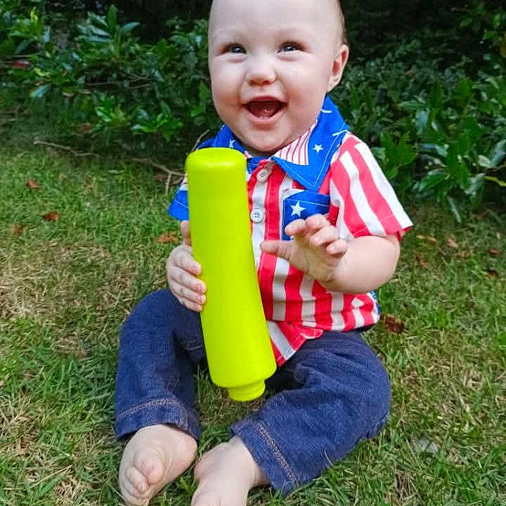 William joined the competition — help win amazing prizes! baby, child, grass, outdoor, smiling, toy, shirt, patriotic, greenery, happy, barefoot, nature, sitting, casual, cute, young, person, playful, daylight, infant
