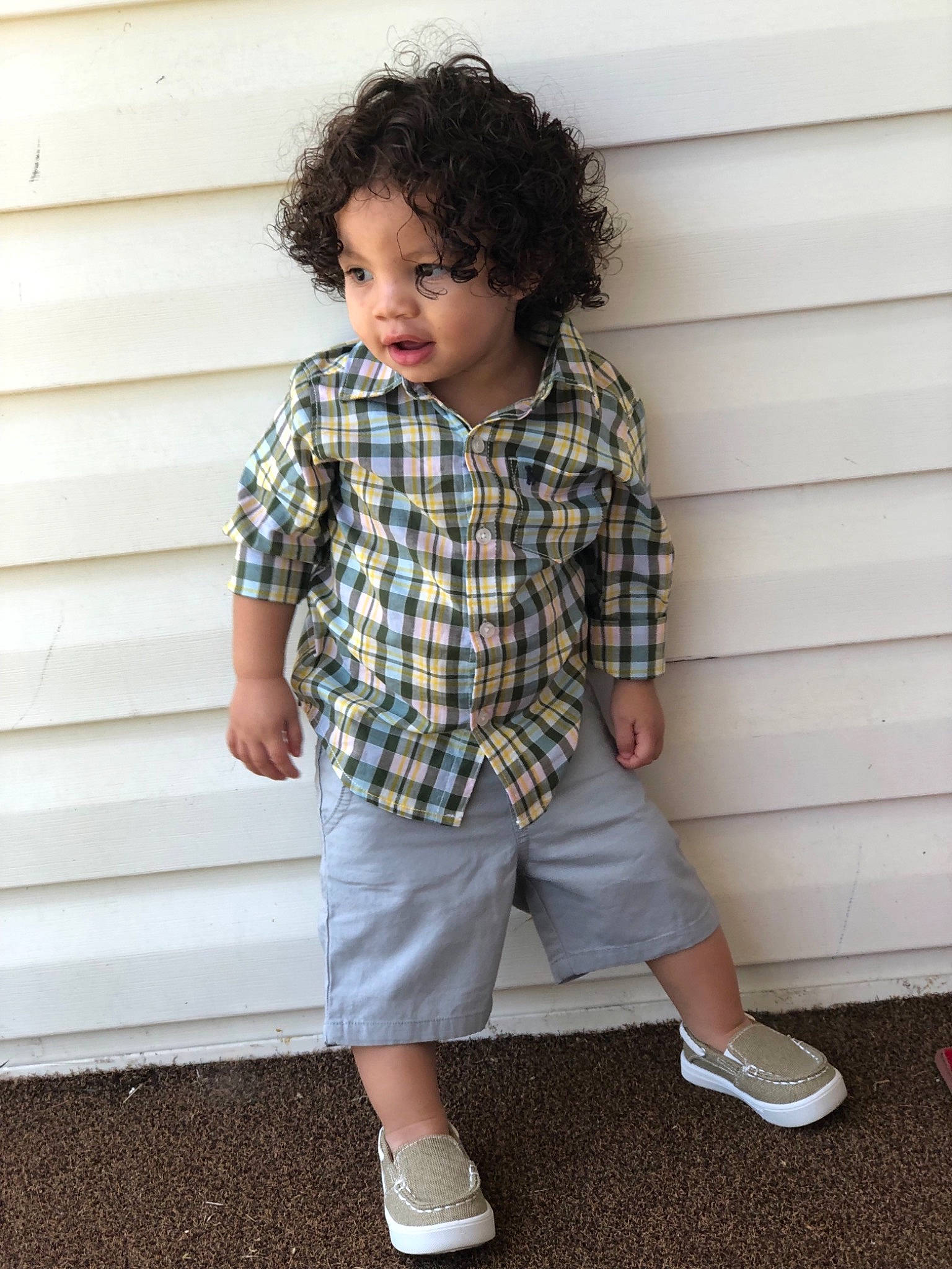 Cortez is registered to the contest to win money with this photo: child, child_model, clothing, cool, design, footwear, hairstyle, leg, male, outerwear, pattern, person, plaid, shoe, sleeve, standing, t_shirt, tartan, textile, toddler