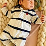 baby, newborn, sleeping, onesie, striped_clothing, blanket, chunky_knit, pacifier_clip, cozy, cute, infant, child, soft, resting, indoors, portrait, peaceful, small_hands, cuddly, warm