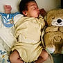 baby, sleeping, teddy_bear, blanket, clothing, socks, infant, bed, cute, cozy, soft_toys, peaceful, rest, child, portrait, indoors, comfort, nap_time, young, sleep