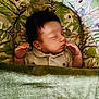 baby, sleeping, blanket, green, koala, leaf_pattern, infant, peaceful, portrait, child, cozy, bedtime, cute, indoors, soft_lighting, resting, small_hands, pajamas, face, young