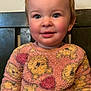 Mia Rose joined the competition — help win amazing prizes! toddler, child, smiling, sweater, pink, yellow, patterned_clothing, blue_eyes, rosy_cheeks, hair_clips, indoor, portrait, cute, happy, person, young_child, seated, cozy, warm_colors, close_up