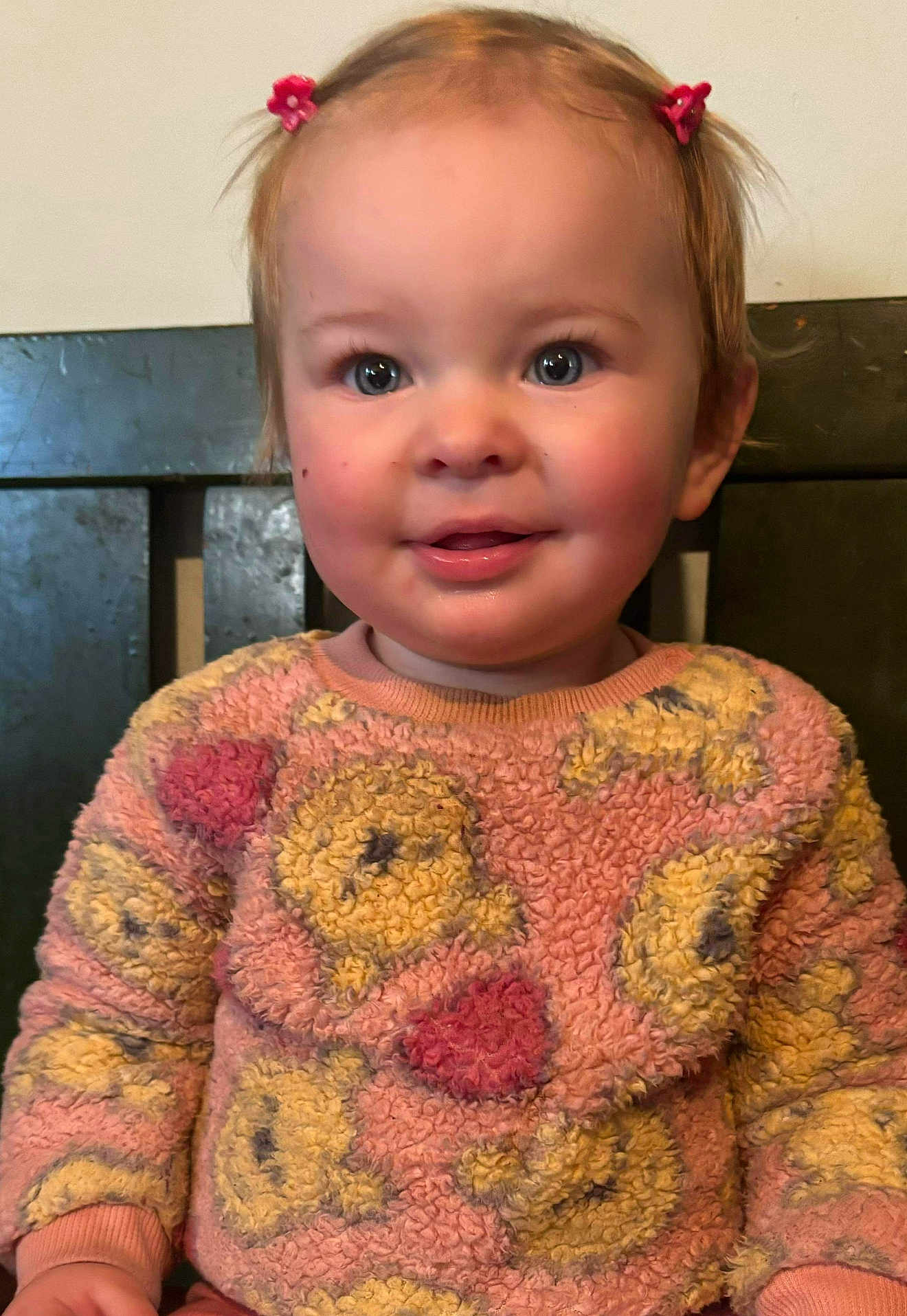 Mia Rose joined the competition — help win amazing prizes! toddler, child, smiling, sweater, pink, yellow, patterned_clothing, blue_eyes, rosy_cheeks, hair_clips, indoor, portrait, cute, happy, person, young_child, seated, cozy, warm_colors, close_up