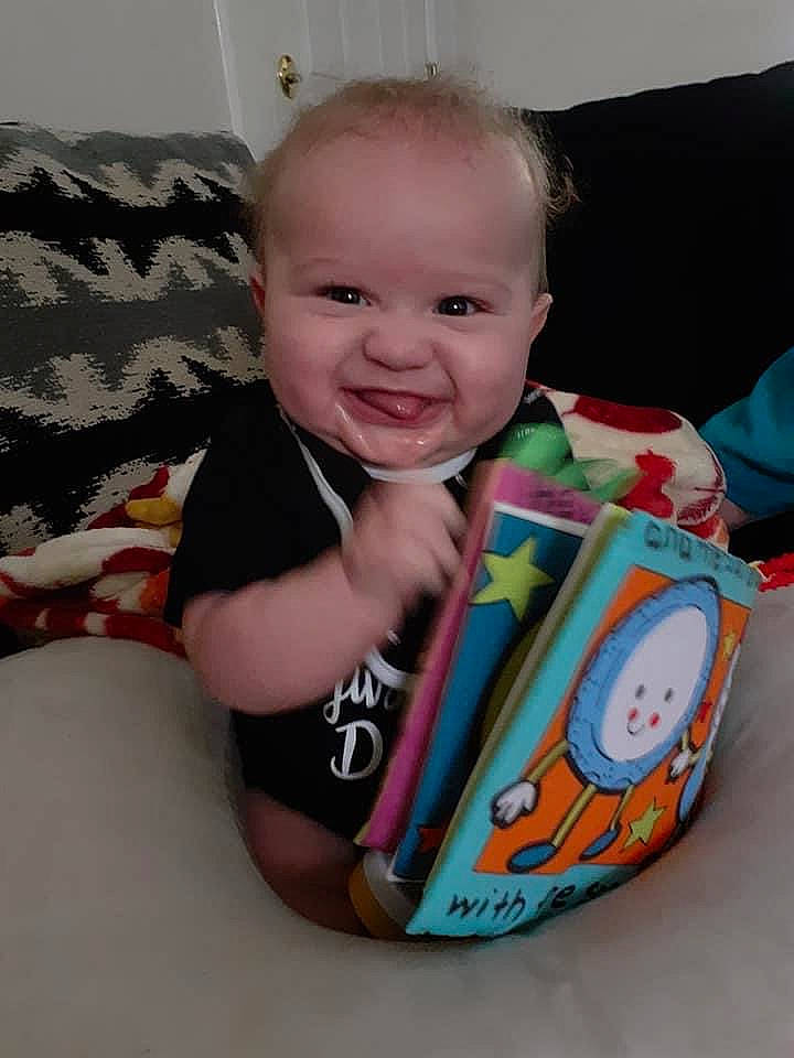 Zachariah is registered to the contest to win money with this photo: baby, baby_products, baby_toddler_clothing, cheek, child, drinkware, eye, hand, happy, human_body, linens, neck, pattern, person, sitting, skin, sleeve, smile, t_shirt, textile