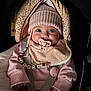 baby, pacifier, hat, pink_clothing, car_seat, straps, beads, bib, infant, cozy, child, cute, face, hands, sitting, warm, indoors, portrait, headwear, apparel