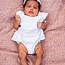 baby, infant, child, white_outfit, headband, curly_hair, lying_down, brown_blanket, texture, cute, fists, portrait, skin, feet, hands, indoors, soft_lighting, expression, closeup, adorable