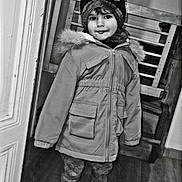 Juliann participe au concours pour gagner de l'argent avec cette photo : child, kid, winter_coat, hat, indoor, doorway, smile, standing, floor, wooden_floor, jacket, fur_hood, shoes, pants, portrait, person, young, cute, warm_clothing, black_and_white