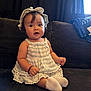 Luz is registered to the contest to win money with this photo: baby, child, girl, hat, dress, sitting, couch, indoors, cute, infant, portrait, smiling, white_socks, braclet, curly_hair, face, person, home, happy, young