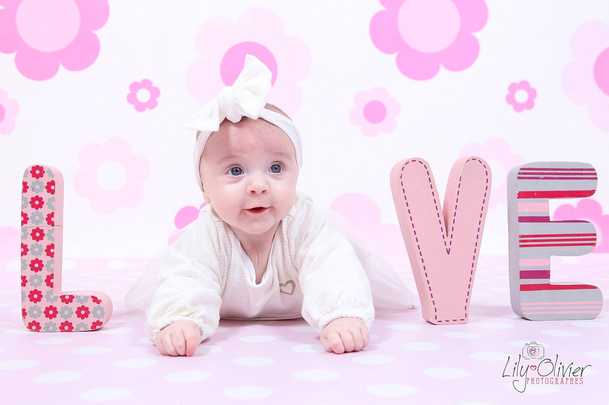 Mathilde participe au concours pour gagner de l'argent avec cette photo : baby, baby_toddler_clothing, font, happy, lighting, magenta, party_supply, pattern, peach, person, pink, product, room, sitting, smile, stock_photography, textile, toddler, vertebrate, violet