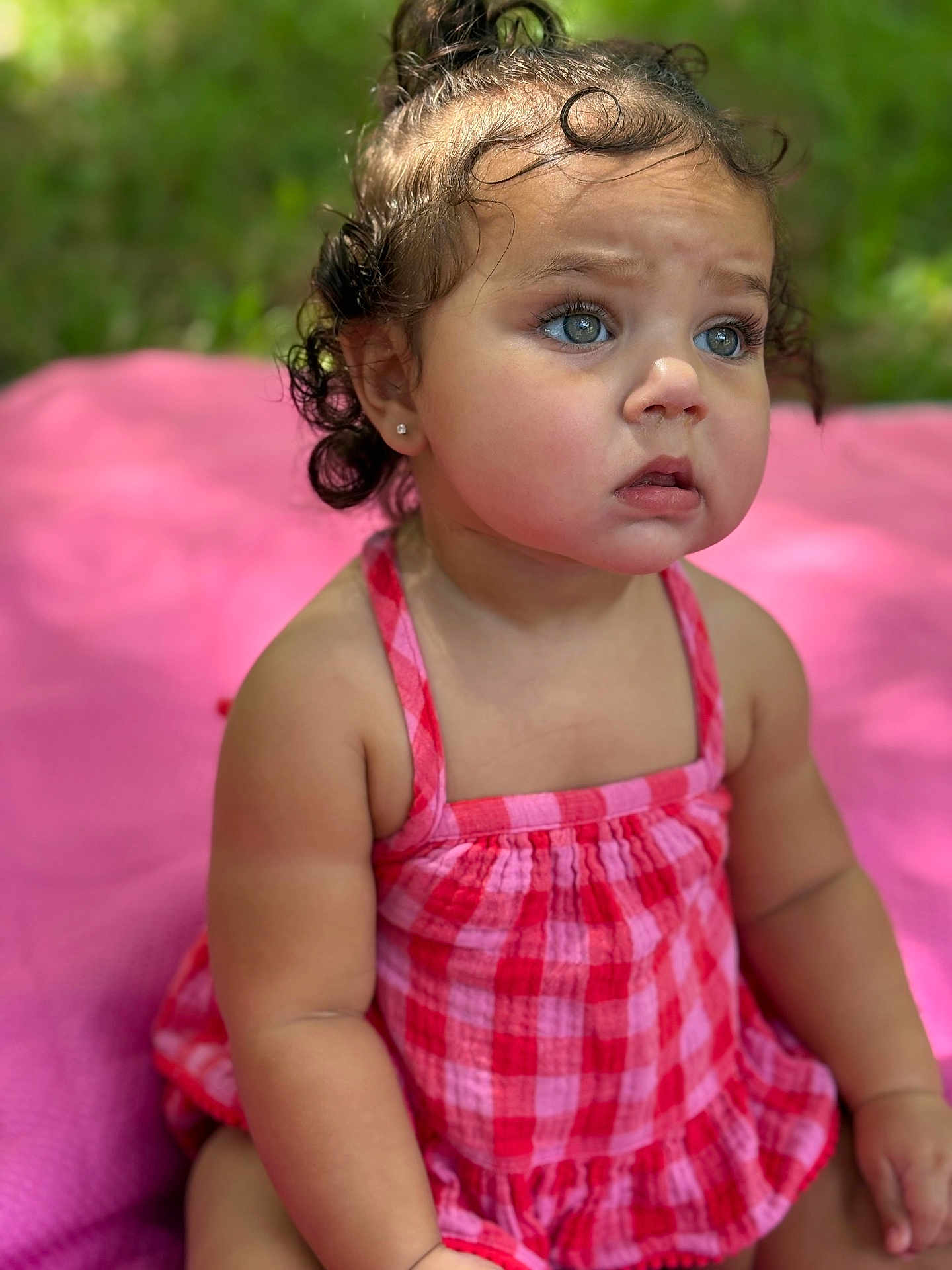 Maisie joined the competition — help win amazing prizes! toddler, child, baby, curly_hair, blue_eyes, pink_blanket, red_dress, checkered_pattern, outdoor, summer, cute, portrait, sitting, innocent, young_child, skin, earrings, expression, nature, soft_light