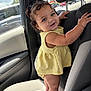 toddler, child, car_interior, car_seat, yellow_dress, curly_hair, standing, holding, window, daylight, happy, cute, person, portrait, automobile, seat, interior, skin, smile, baby