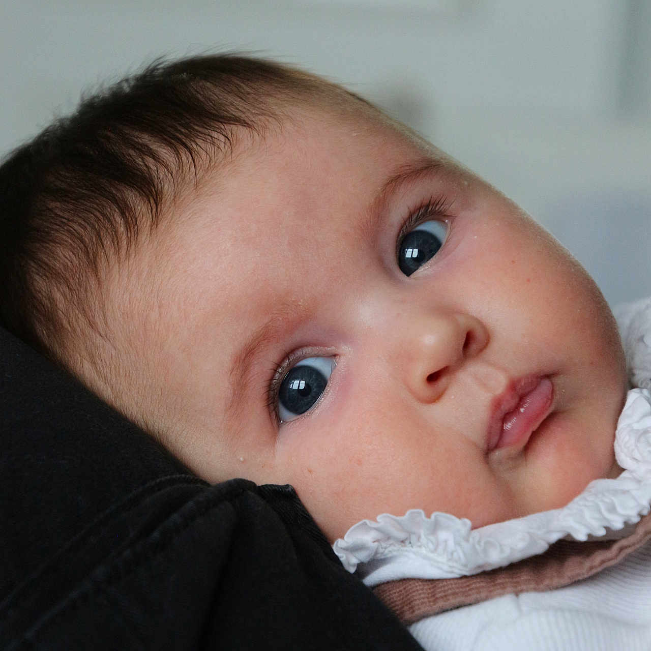 Aria is registered to the contest to win money with this photo: baby, bodypart, bonnet, clothing, face, finger, frown, hand, hat, head, hood, hoodie, knitwear, mouth, newborn, person, photography, portrait, sweater, sweatshirt