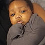 Kyrie is registered to the contest to win money with this photo: baby, child, face, portrait, cozy, gray_clothing, infant, cute, young_child, indoors, skin, eyes, hand, sleeve, person, closeup, expression, sleepwear, resting, soft_lighting