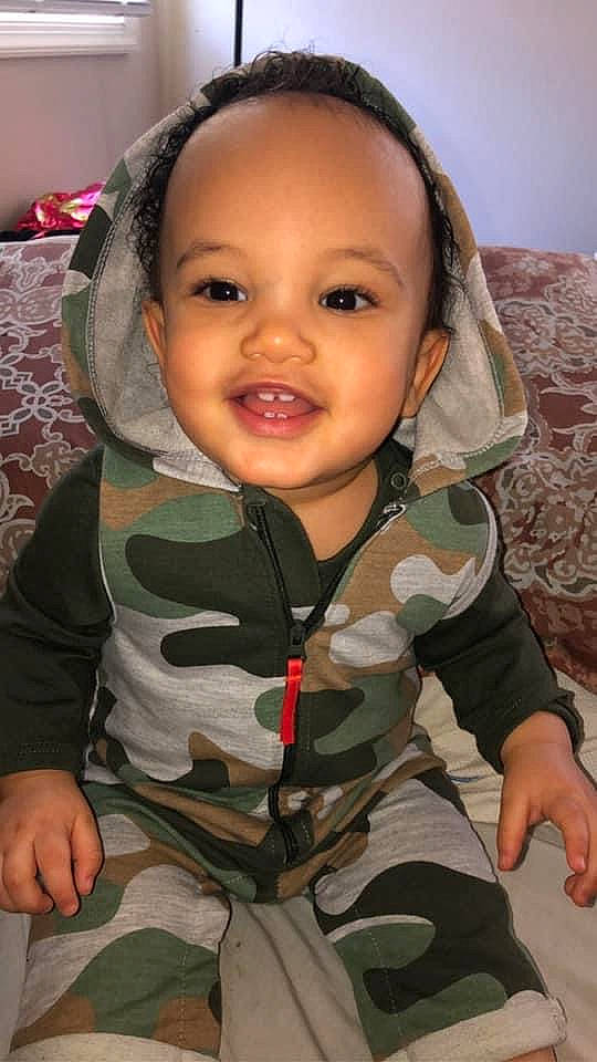 Jj is registered to the contest to win money with this photo: baby, baby_toddler_clothing, camouflage, cheek, comfort, eye, eyelash, finger, gesture, happy, head, lip, military_camouflage, mouth, neck, nose, person, skin, sleeve, smile