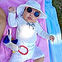 baby, child, sunglasses, hat, towel, outdoor, plush_toy, white_clothing, pink_towel, blue_towel, grass, sunlight, cute, infant, relaxing, summer, accessory, person, leisure, toy