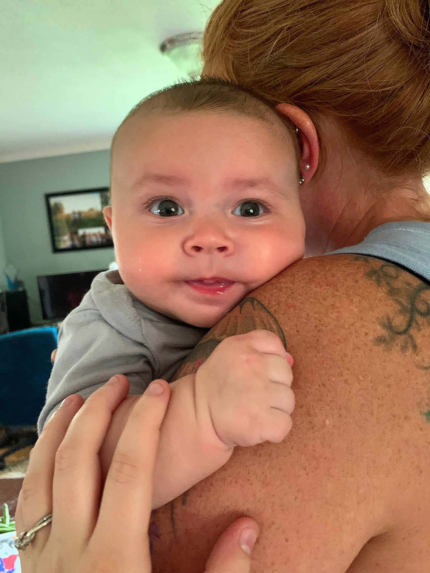 Cullen is registered to the contest to win money with this photo: adult, baby, bonding, child, closeup, cute, expression, face, family, hand, holding, human, human_hand, indoor, infant, love, person, shoulder, skin, tattoo