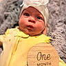 Luna joined the competition — help win amazing prizes! baby, blanket, child, clothing, cozy, cute, eyes, face, flower_headband, headband, indoor, infant, milestone, newborn, one_month, person, portrait, soft_texture, wooden_sign, yellow_outfit