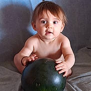 Djovani participe au concours pour gagner de l'argent avec cette photo : baby, child, watermelon, fruit, curious, wide_eyes, shirtless, sitting, indoor, soft_background, light_skin, brown_hair, hands, large_object, grip, portrait, infant, cute, expression, food