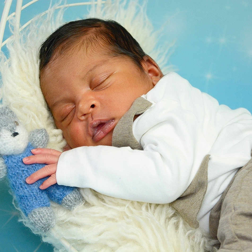 Noah a rejoint le concours — aidez-le/la à gagner de superbes lots ! newborn, baby, sleeping, teddy_bear, knitted_toy, white_blanket, soft_texture, blue_background, star_pattern, peaceful, infant, cute, child, portrait, cozy, resting, clothing, long_sleeve, laying_down, close_up