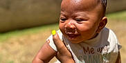 King joined the competition — help win amazing prizes! baby, child, smiling, outdoor, sunlight, bib, hand, arm, bracelet, nail_polish, person, portrait, grass, blurred_background, happy, cute, skin, head, earring, infant