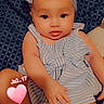 baby, infant, child, portrait, smiling, bow_headband, striped_outfit, romper, sitting, indoors, couch, blanket, patterned_background, close_up, face, eyes, hands, legs, heart_sticker, date_stamp