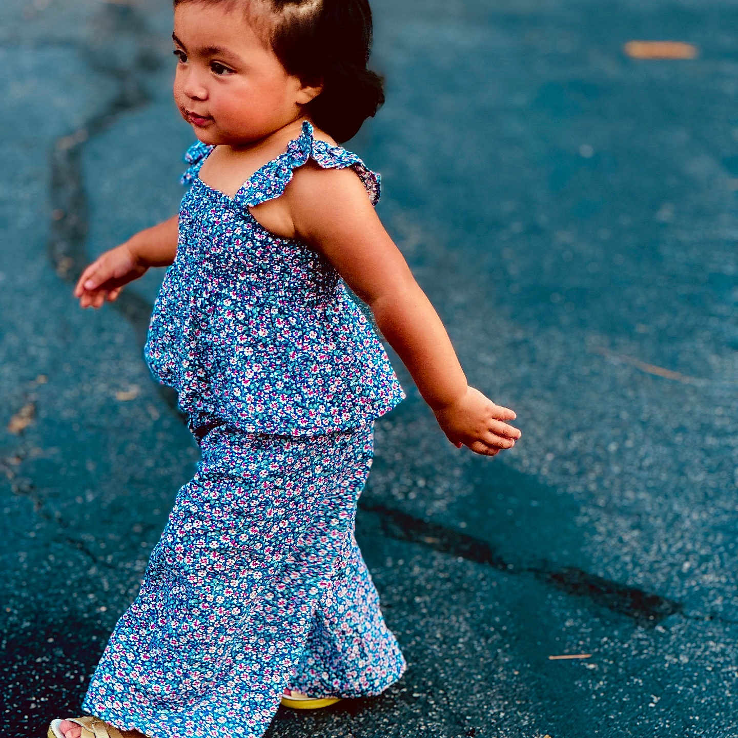 Abigail joined the competition — help win amazing prizes! blue_flower_clothing, casual, child, curly_hair, cute, expression, fashion, girl, hair_accessory, natural_light, outdoor, pavement, playful, portrait, sandals, side_view, summer, toddler, walking, young_child