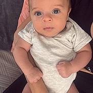 Swann a rejoint le concours — aidez-le/la à gagner de superbes lots ! baby, infant, person, arms, clothing, onesie, face, skin, hand, fingers, legs, cushion, blanket, indoor, human, child, closeup, holding, seated, soft