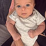 baby, infant, person, arms, clothing, onesie, face, skin, hand, fingers, legs, cushion, blanket, indoor, human, child, closeup, holding, seated, soft