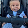 baby, child, stroller, smile, happy, infant, seatbelt, clothing, white_shirt, gray_pants, cute, portrait, outdoor, person, young_child, cheeky_smile, closeup, baby_face, safety_harness, casual_wear