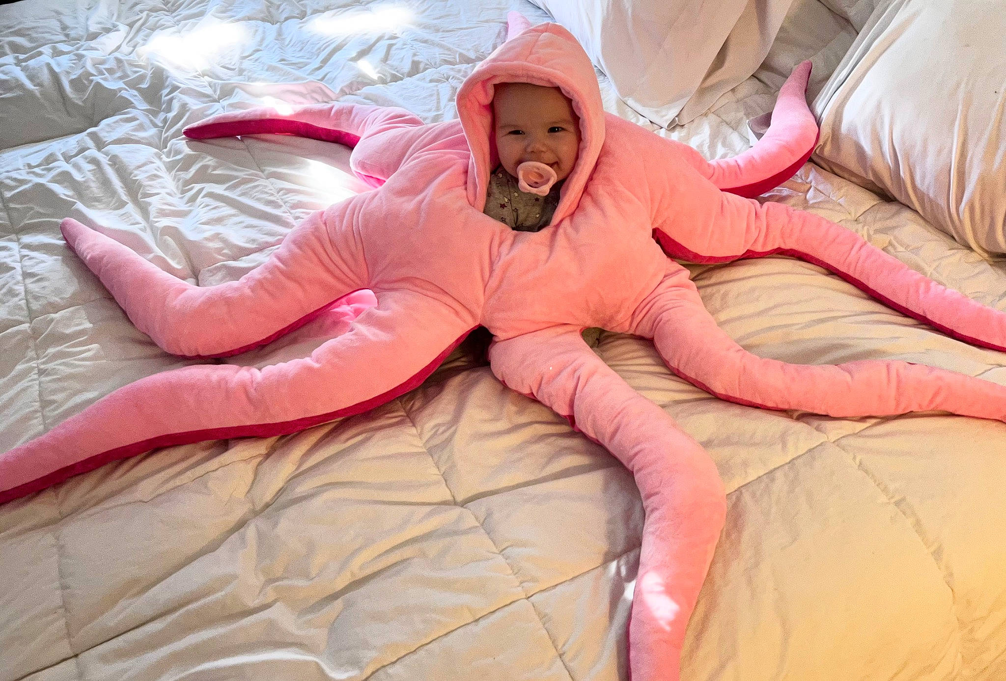 Raven is registered to the contest to win money with this photo: bedding, carmine, comfort, eye, flesh, flooring, foot, fun, fur, hat, headwear, leisure, linens, magenta, peach, person, pink, recreation, room, smile