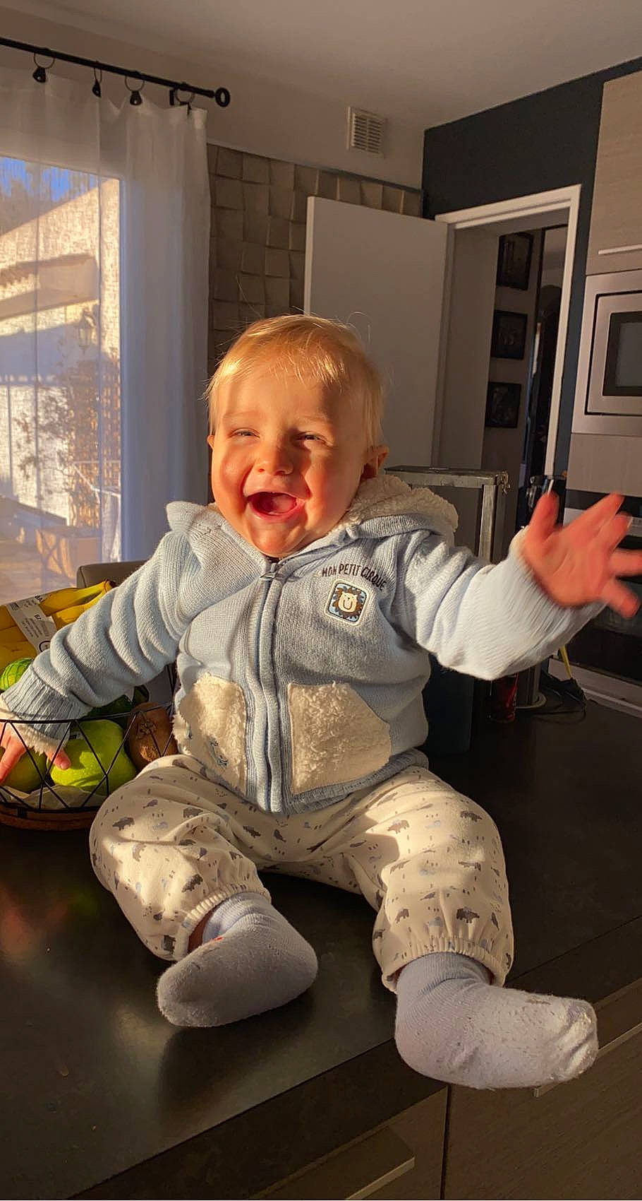 Marlonn participe au concours pour gagner de l'argent avec cette photo : baby, baby_toddler_clothing, cheek, child, comfort, eye, floor, flooring, fun, gesture, hairstyle, happy, leg, person, sitting, skin, sleeve, smile, standing, toddler